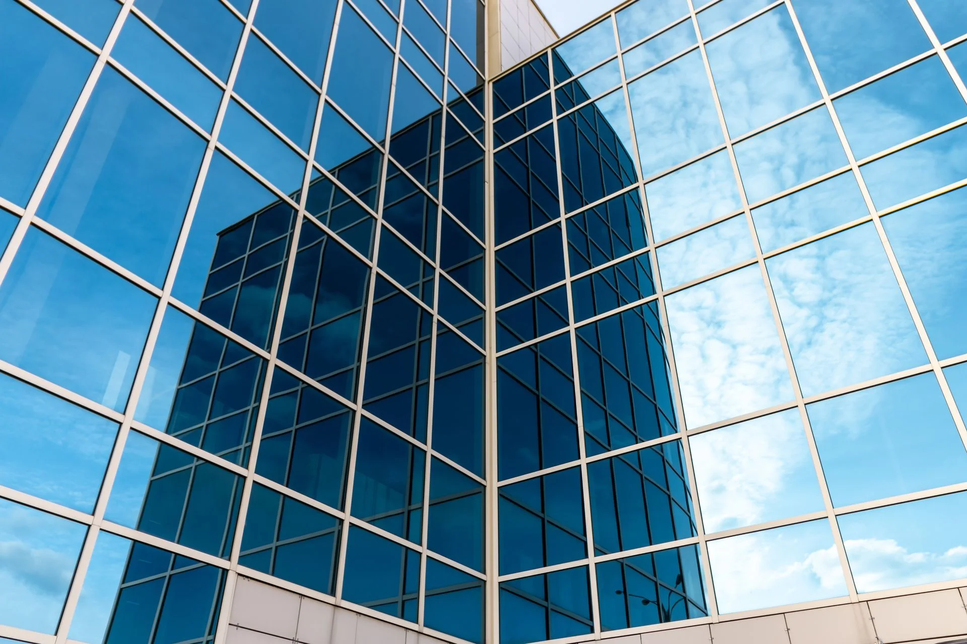 Modern commercial building with a large glass façade, where commercial window film helps reduce heat and glare for the workspace inside